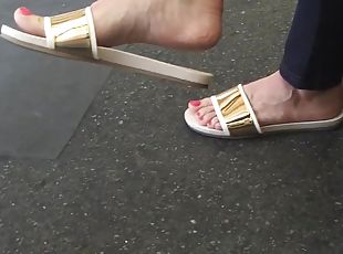 Sexy feet at London tube station, red toes dangling feet